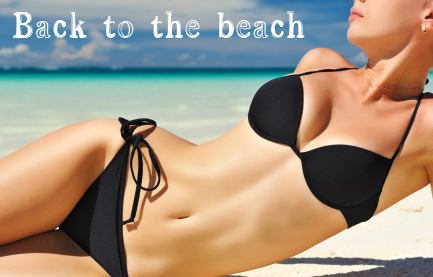 Woman in a black bikini lies on her side on the beach.