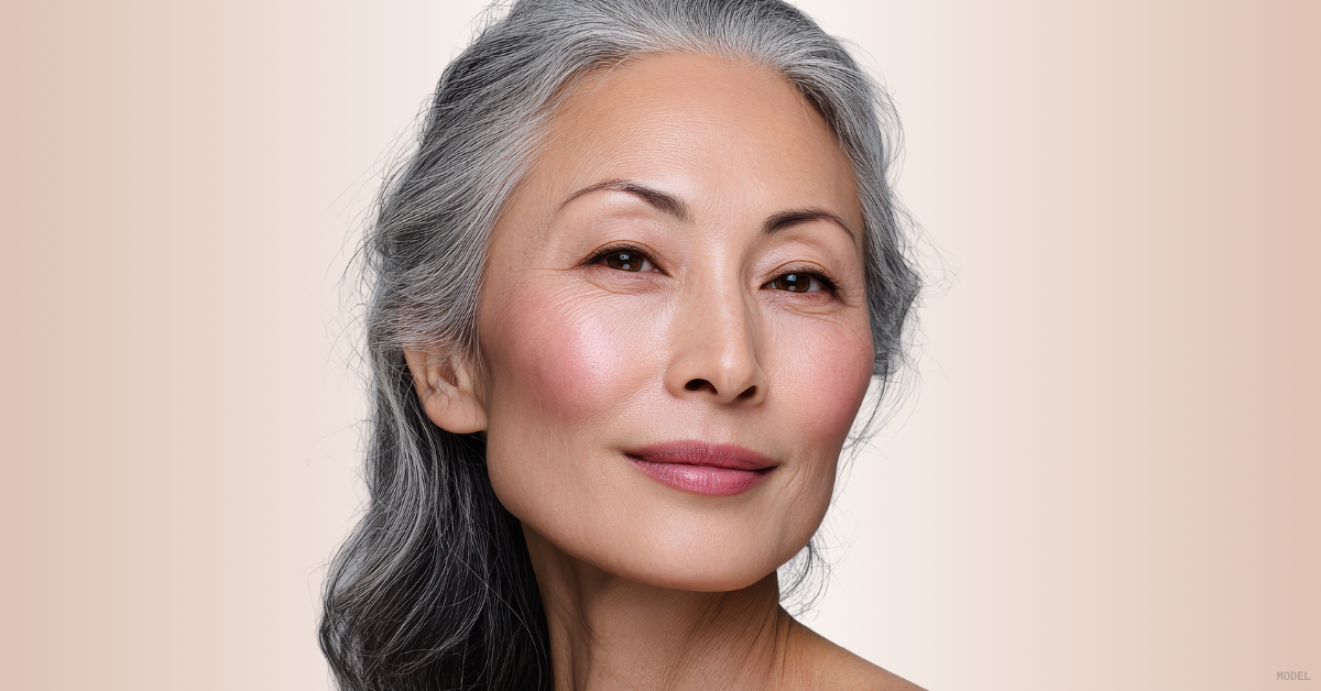 Close-up of a mature woman (model) against a soft beige background.